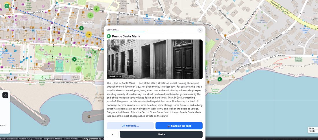 A tour stop screen showing a historic photo of Rua de Santa Maria with narration and a Stand on the Spot button
